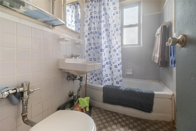 full bathroom featuring shower / bath combination with curtain, toilet, sink, and tile walls