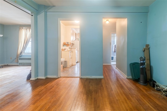 empty room featuring radiator and hardwood / wood-style floors