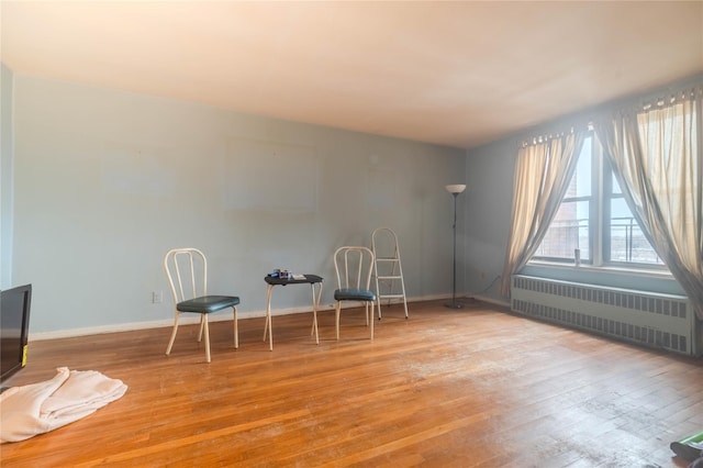 unfurnished room with radiator heating unit and light wood-type flooring