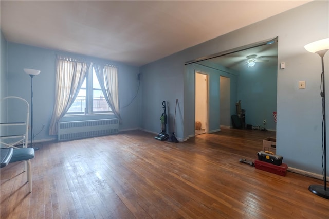 unfurnished living room featuring hardwood / wood-style flooring, radiator heating unit, and ceiling fan