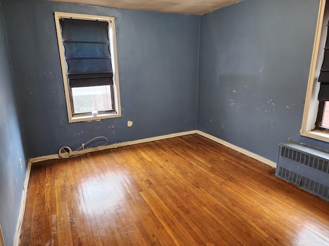 spare room featuring wood-type flooring and radiator