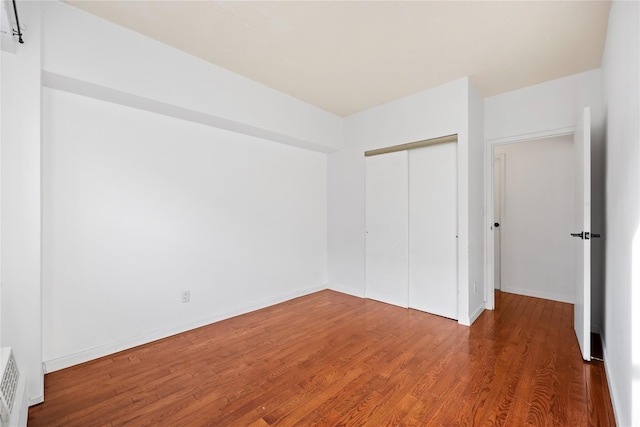 unfurnished bedroom featuring dark hardwood / wood-style floors and a closet