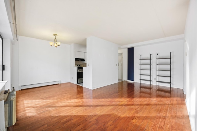 unfurnished room with hardwood / wood-style flooring, an inviting chandelier, and a baseboard heating unit