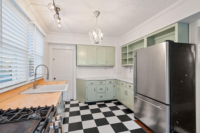 kitchen with green cabinets, sink, and appliances with stainless steel finishes