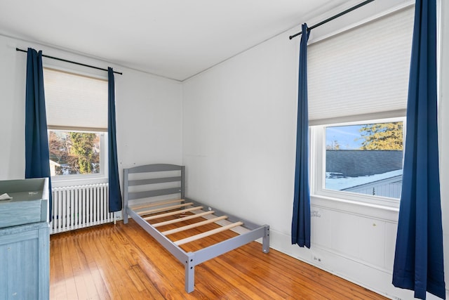 bedroom with hardwood / wood-style flooring and radiator