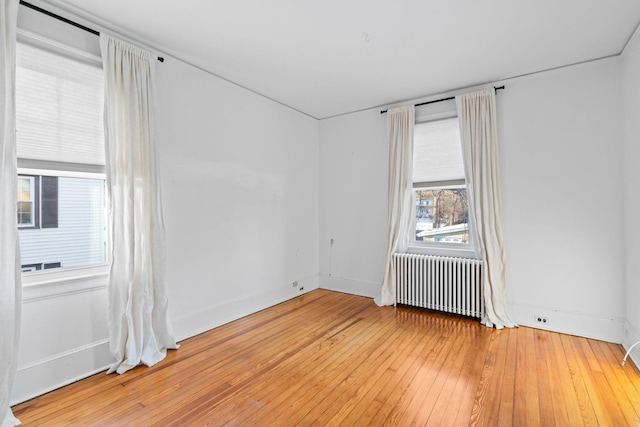 spare room with wood-type flooring and radiator heating unit