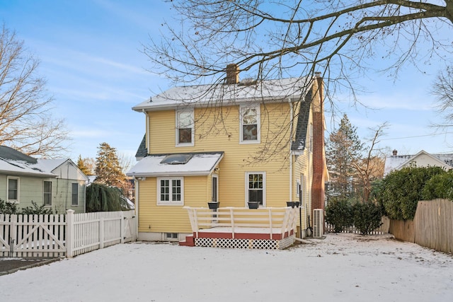 snow covered rear of property featuring a deck