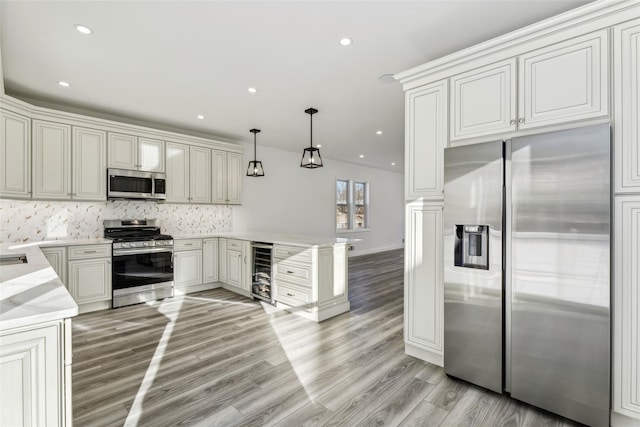 kitchen with stainless steel appliances, wine cooler, kitchen peninsula, decorative light fixtures, and decorative backsplash