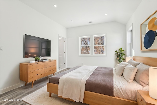 bedroom featuring hardwood / wood-style floors and vaulted ceiling