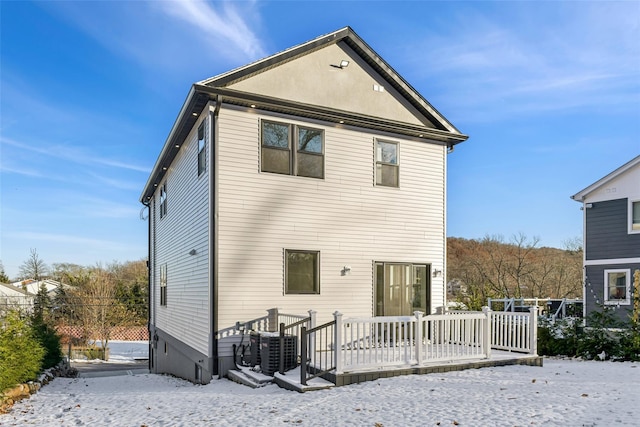 snow covered property with a deck