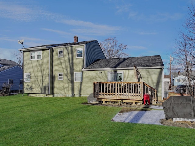 rear view of house featuring a lawn and a deck