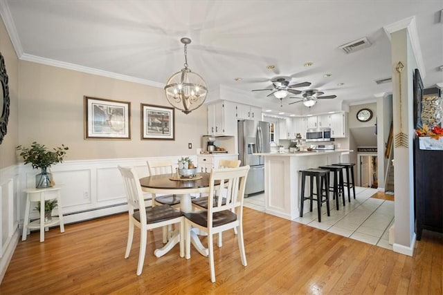 dining space featuring light wood-type flooring, an inviting chandelier, and crown molding