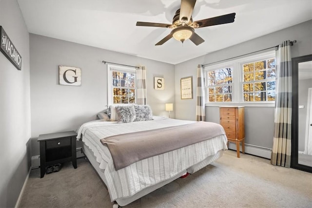 carpeted bedroom featuring ceiling fan and a baseboard heating unit