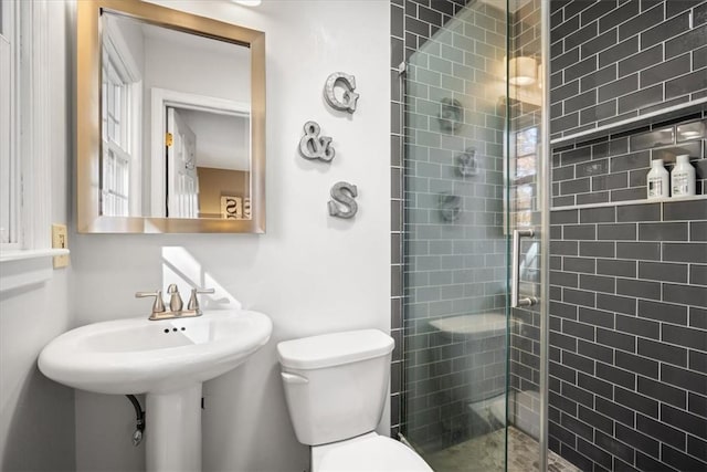 bathroom with toilet and an enclosed shower