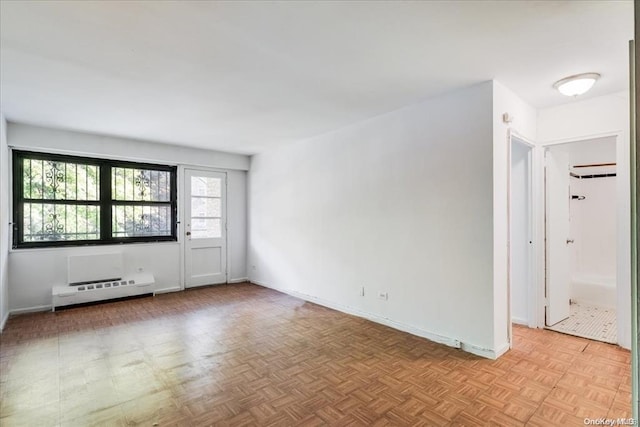 empty room featuring baseboard heating and light parquet flooring