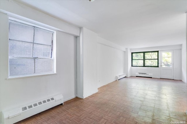 spare room featuring parquet flooring and a baseboard heating unit