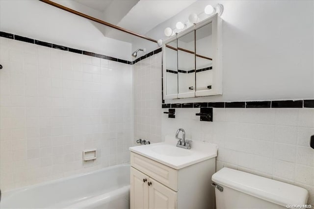 full bathroom with tile walls, toilet, decorative backsplash, vanity, and tiled shower / bath combo