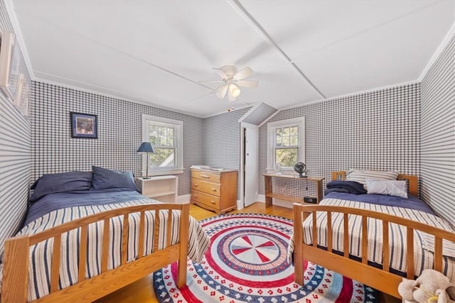 bedroom with hardwood / wood-style floors, ceiling fan, ornamental molding, and multiple windows