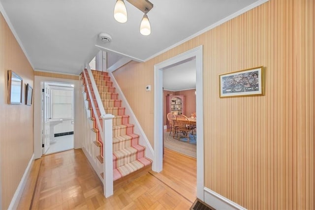 stairway featuring parquet floors and crown molding