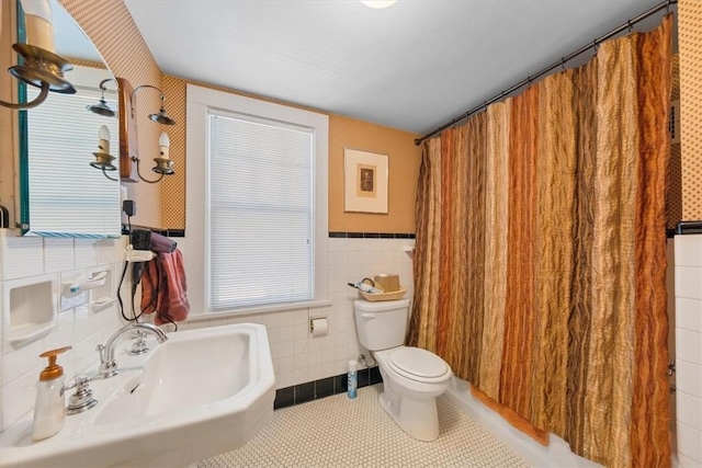 full bathroom with shower / bath combination with curtain, sink, tile walls, tile patterned flooring, and toilet