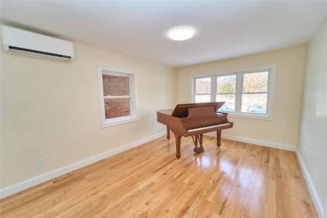 misc room featuring a wall mounted AC and light hardwood / wood-style floors