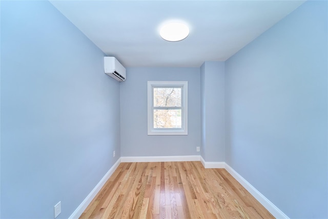 unfurnished room featuring a wall mounted air conditioner and light wood-type flooring