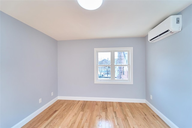 empty room with a wall mounted air conditioner and light hardwood / wood-style flooring