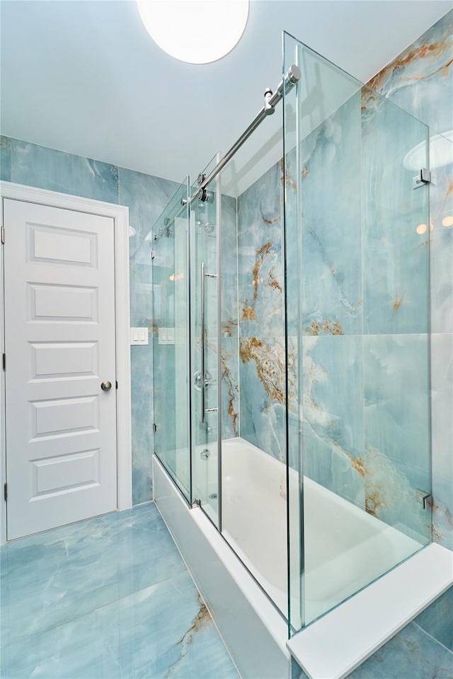 bathroom with bath / shower combo with glass door