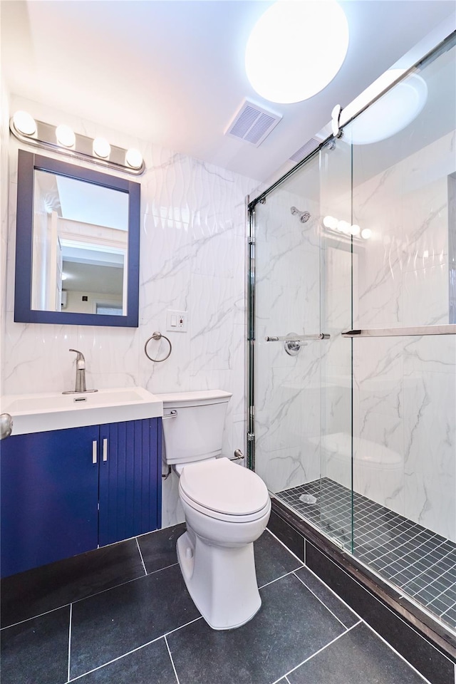 bathroom with an enclosed shower, vanity, toilet, and tile walls