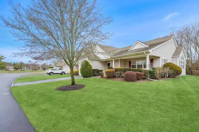 view of side of property with covered porch and a yard