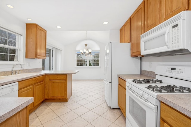 kitchen with white appliances, sink, pendant lighting, light tile patterned floors, and a chandelier