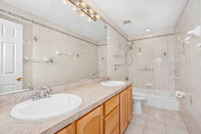 full bathroom with tub / shower combination, vanity, tile walls, tile patterned flooring, and toilet