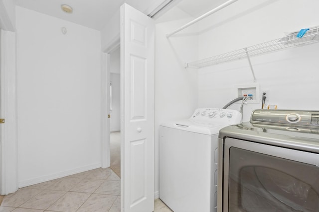 laundry room with light tile patterned floors and separate washer and dryer