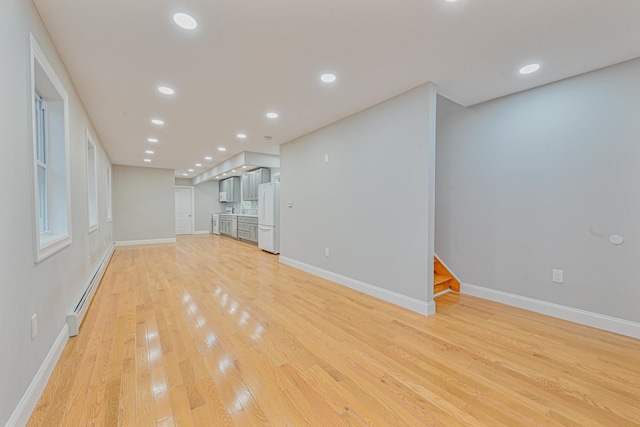 unfurnished living room featuring light hardwood / wood-style floors and baseboard heating