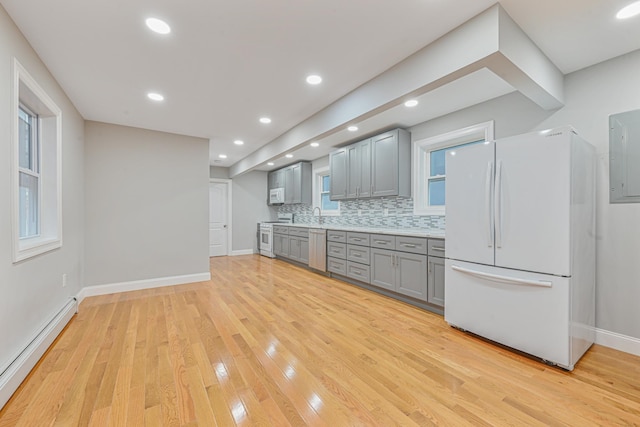 kitchen featuring tasteful backsplash, a baseboard heating unit, white appliances, gray cabinets, and light wood-type flooring