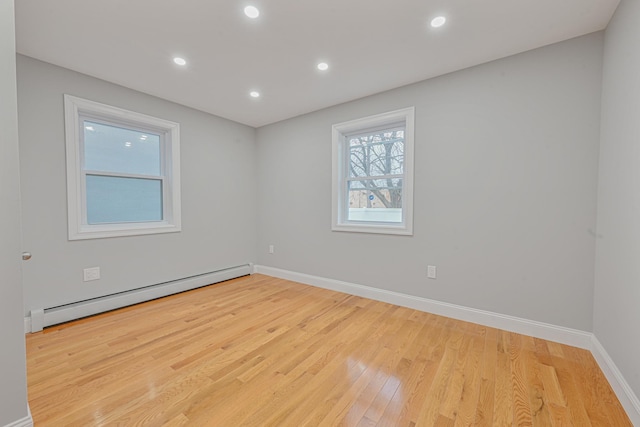 spare room featuring light hardwood / wood-style flooring and a baseboard heating unit