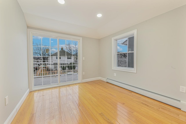 empty room featuring hardwood / wood-style flooring and baseboard heating