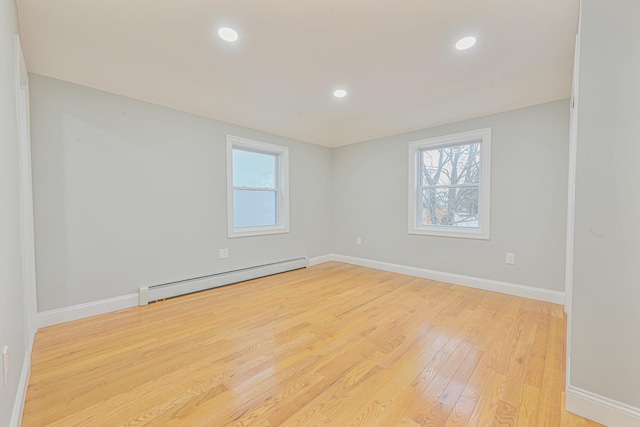 spare room featuring light wood-type flooring and a baseboard radiator