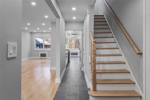 staircase with hardwood / wood-style floors, ornamental molding, and a wall mounted AC