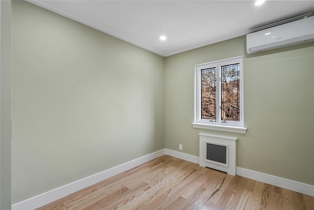 empty room featuring light hardwood / wood-style floors and a wall unit AC