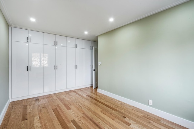 unfurnished bedroom with light hardwood / wood-style floors and a closet