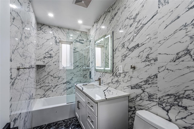 full bathroom with shower / tub combination, vanity, toilet, and tile walls