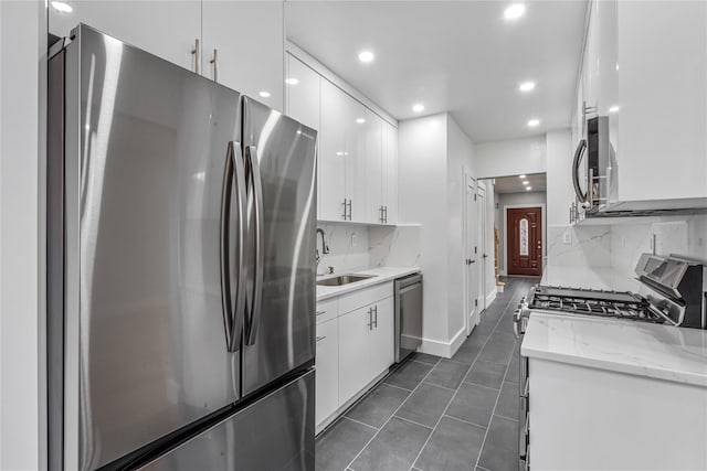 kitchen featuring tasteful backsplash, white cabinetry, sink, and stainless steel appliances