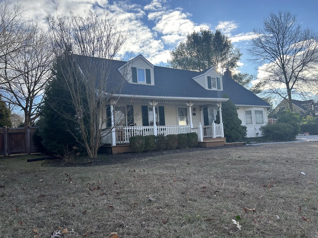 cape cod home featuring covered porch and a front yard