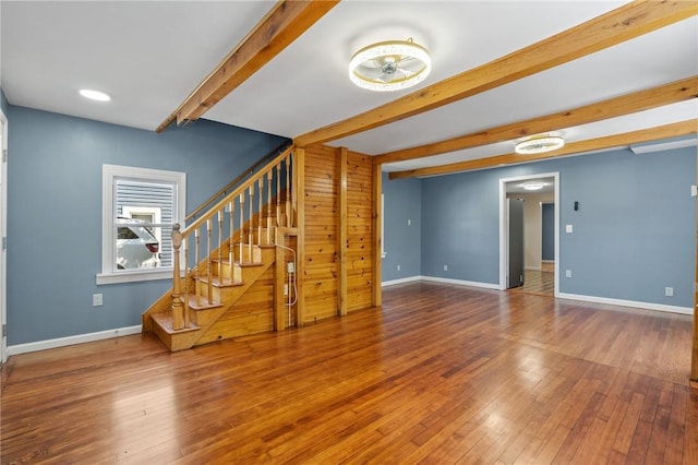 unfurnished living room featuring hardwood / wood-style flooring and beam ceiling