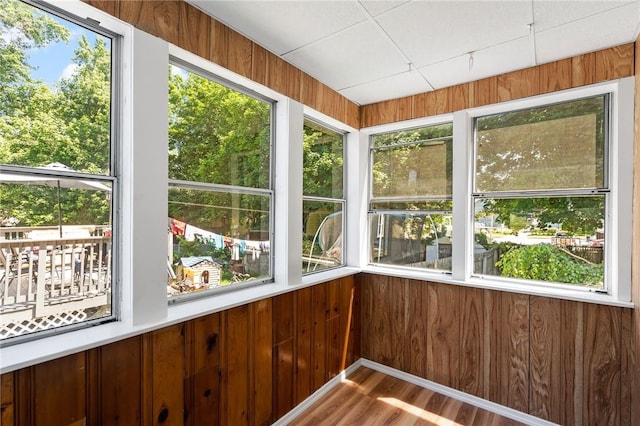 unfurnished sunroom featuring a paneled ceiling and plenty of natural light