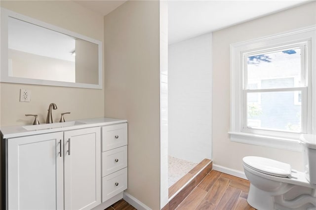 bathroom with vanity, toilet, walk in shower, and a wealth of natural light