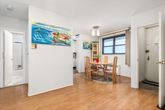 dining area featuring light wood-type flooring and radiator