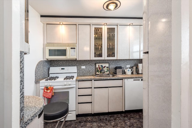 kitchen with tasteful backsplash, sink, and white appliances