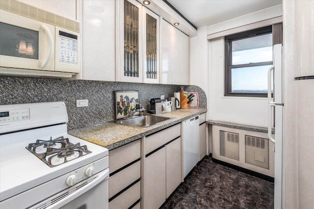 kitchen featuring decorative backsplash, white appliances, and sink